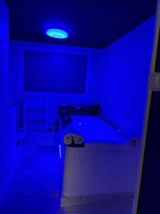 une salle de bains bleue pourvue d'une baignoire. dans l'établissement Logements jacuzzi silencieux, à Deuil-la-Barre