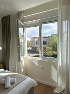 a bedroom with a large window and a bed at Japandi Home in Niš