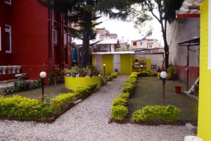 un giardino con fiori e piante di fronte a un edificio di My Garden House a Kathmandu