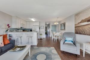 Winds II في كارولينا بيتش: غرفة معيشة ومطبخ مع أريكة وكراسي