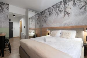 sypialnia z dużym białym łóżkiem z malowidłem ściennym w obiekcie Flow Apartments - przy Mariackiej w mieście Katowice