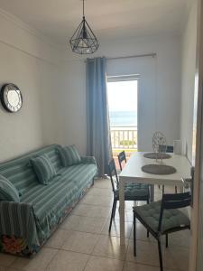 a living room with a couch and a table at Manolis House in Nea Potidaea