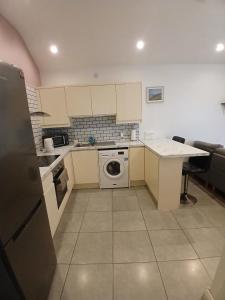 a kitchen with white cabinets and a washer and dryer at D17 Accommodation - Dublin Airport in Dublin