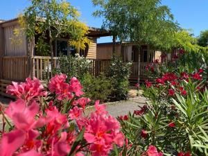 ein Garten mit rosa Blumen vor einem Haus in der Unterkunft Camping Resort Els Pins in Malgrat de Mar