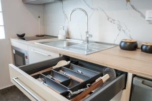 eine offene Schublade in einer Küche mit Spüle in der Unterkunft Heleon Luxury Apartments in Parga