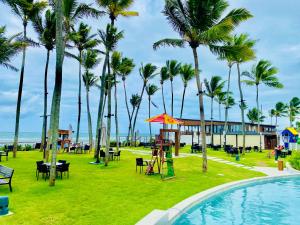 a resort with a pool and palm trees at Porto Alto Resort in Porto De Galinhas