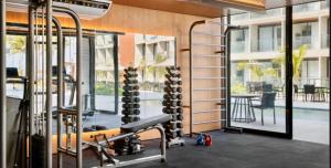 a gym with a lot of equipment and a swimming pool at Porto Alto Resort in Porto De Galinhas