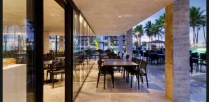 a restaurant with tables and chairs on a balcony at Porto Alto Resort in Porto De Galinhas