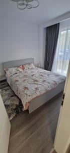 a bedroom with a bed with a floral comforter at LuxAsher in Floreşti