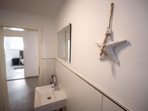 a bathroom with a sink and a starfish on the wall at Wohlfühloase - Moderne Ferienwohnung mit großem eingezäuntem Garten in Alleinlage an Feld & Wald, Natur pur trifft auf Komfort, Wellness und gute Erholung in Alpen +46 photos