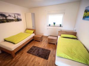 a bedroom with two beds and a window at Wohlfühloase - Moderne Ferienwohnung mit großem eingezäuntem Garten in Alleinlage an Feld & Wald, Natur pur trifft auf Komfort, Wellness und gute Erholung in Alpen