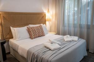 a bedroom with a bed with towels on it at Heleon Luxury Apartments in Parga