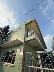 a small green building with a balcony on it at Octagon in Caylaway +15 photos