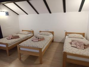 a room with three beds in a room at Naid Apartmani in Kulen Vakuf