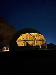 Ein Gebäude mit einer nachts beleuchteten Kuppel in der Unterkunft Magic mountains rum in Disah