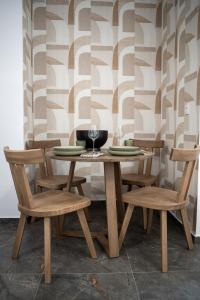 ein Holztisch mit zwei Stühlen und einem Weinglas in der Unterkunft Heleon Luxury Apartments in Parga + 51 Fotos