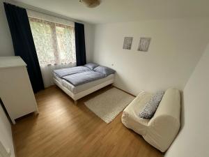 una pequeña habitación con una cama y un sofá en ubytování u Hraničního zámečku Hlohovec u Břeclavě, en Břeclav