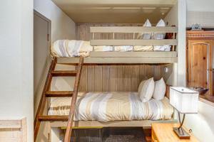 two bunk beds in a small room with a desk at Walk to Shops & Eats: Mammoth Lakes Condo w/ Pool in Mammoth Lakes +17 photos
