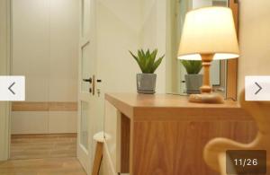 a lamp on a wooden desk with a mirror at Cozy Apartment Near Holiday Inn in Tbilisi City +14 photos
