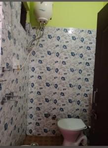 a bathroom with a toilet and a shower curtain at Kartikey homestay and restaurant in Gopeshwar