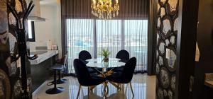 a dining room with a table and chairs and a window at Torre 5 Mazatlán Versace Style in Mazatlán