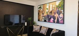 a living room with a flat screen tv and a couch at Torre 5 Mazatlán Versace Style in Mazatlán