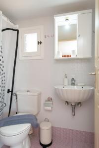 a bathroom with a toilet and a sink and a mirror at Mavroudis House Sifnos in Sifnos