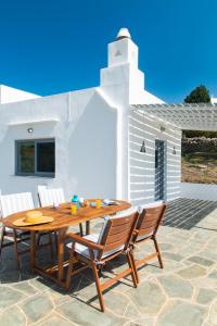 a wooden table and chairs on a patio at Mavroudis House Sifnos in Sifnos