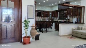 a living room and kitchen with a door and a plant at Country House in Wadi Musa