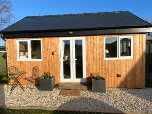 a tiny house with a black roof and windows at The Garden Rooms in Spittal