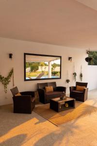 a living room with couches and a large mirror at VILLA DA COSTA - SUNSET POOLHOUSE in Alvarães