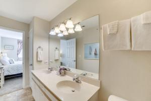 a bathroom with a sink and a mirror and a bed at 3 Mi to Branson Landing Condo with Pool Access in Branson +20 photos