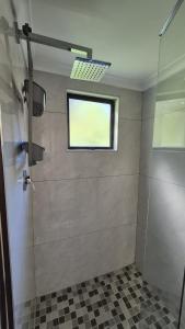 a bathroom with a shower with a window at Chase Valley Hideaway in Pietermaritzburg