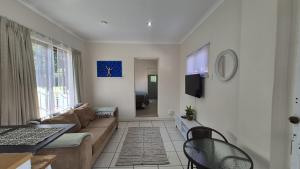 a living room with a couch and a table at Chase Valley Hideaway in Pietermaritzburg +4 photos