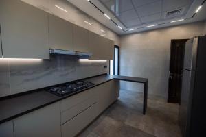 a kitchen with white cabinets and a black counter top at Villa 22 in Ajman 