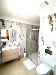 Un baño con ducha, inodoro y lavabo. en La Perla Exotica, en Los Realejos