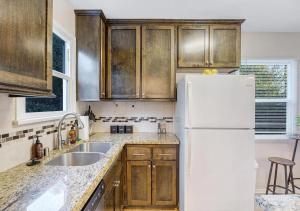 a kitchen with wooden cabinets and a white refrigerator at Balcom Breeze Escape in Los Angeles