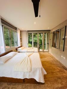 a large bedroom with two beds and large windows at Villa Mel in Punta Leona