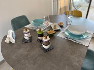 a table with food and plates on top of it at T2 Appartement Sunset Lodge à 250 m de la mer, 3 couchages in Narbonne-Plage +23 photos