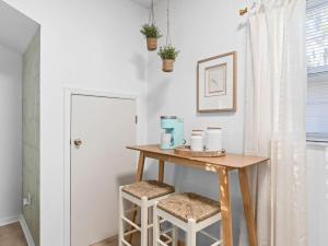 a small table with two stools in a room at SUPER BOHO- At LAKE TOHO's WATER SLEEPs 6 in Kissimmee