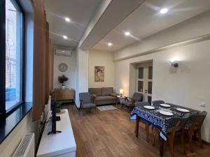 a living room with a table and a dining room at Cozy Apartment Near Holiday Inn in Tbilisi City