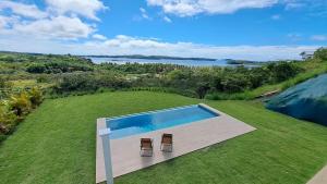 a swimming pool with two stools on a lawn at Casa Bonita at Hermosa Bay in Boca Chica