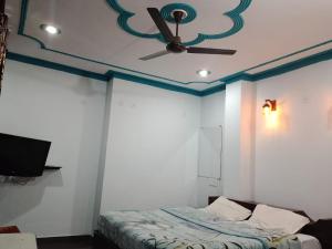 ein Schlafzimmer mit Deckenventilator und einem Bett in der Unterkunft HOTEL GRAND GLORRYy in Pauri + 29 Fotos