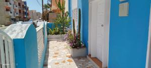une ruelle étroite avec des murs bleus et des plantes en pot dans l'établissement Residencial Soares, à Espargos