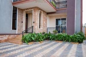 a house with a bunch of plants in front of it at WanderHome 1BDR in Kampala