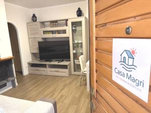 a room with a tv and a wall with a sign at Casa Magri in Marina di Cerveteri
