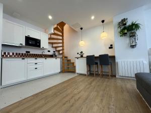 a kitchen and living room with white cabinets and a staircase at Loft avec Jaccuzi in Le Mans