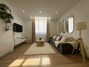 a living room with a couch and a tv at Loft avec Jaccuzi in Le Mans