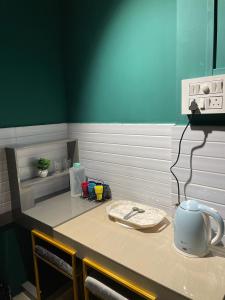 River View Homestay في ديبروجاره: طاولة مطبخ مع طاولة عليها غلاية ماء