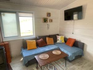 a couch with pillows on it in a room at Jaunas Ilgas in Medumi